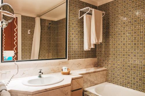 a bathroom with a sink and a tub at Kanta Resort and Spa in Sousse