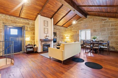 a living room with a fireplace and a dining room at Abrigo do Mezio - Country House in Mezio