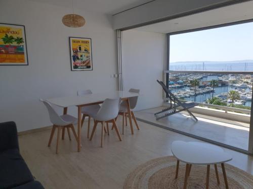 une salle à manger avec une table, des chaises et une grande fenêtre dans l'établissement Vue mer exceptionnelle, au Lavandou