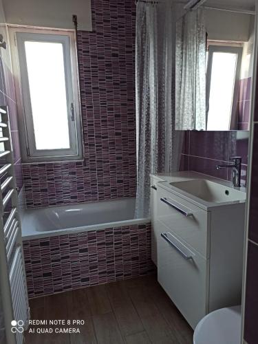 La salle de bains est pourvue d'une baignoire, d'un lavabo et d'une baignoire. dans l'établissement Vue mer exceptionnelle, au Lavandou