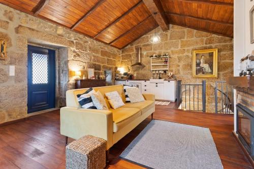 a living room with a couch and a kitchen at Abrigo do Mezio - Country House in Mezio