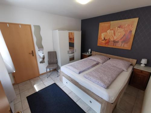 a bedroom with a bed and a painting on the wall at Ferienwohnung Emma in Konz