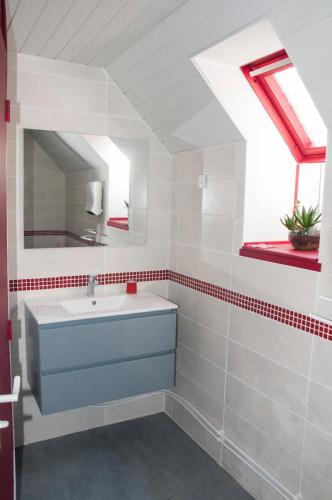 une salle de bain avec un lavabo et un miroir dans l'établissement Un coin de forêt, à Courmas