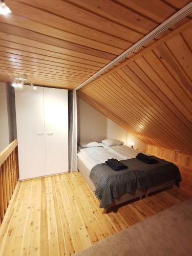 a bedroom with a bed and a wooden ceiling at Gold Legend Paukkula #3 - Saariselkä Apartments in Saariselka