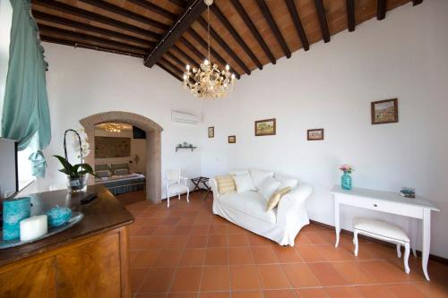 uma sala de estar com um sofá branco e uma mesa em Podere Le Volte Country House La Mita em Civitella in Val di Chiana
