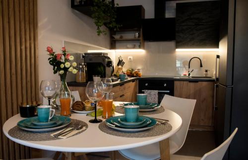 a table with plates and glasses on it in a kitchen at APARTAMENT BIESZCZADY in Ustrzyki Dolne