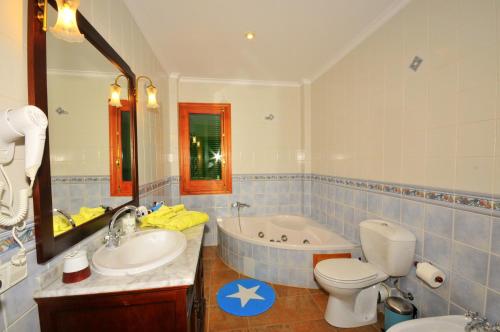 a bathroom with a tub and a toilet and a sink at Villa Mallorca Paradise in Llucmajor