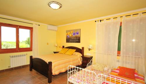 a bedroom with a bed and a crib in it at Villa Mallorca Paradise in Llucmajor