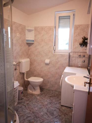 a bathroom with a toilet and a sink at Apartments Tara in Ražanac