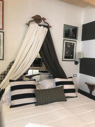 a bedroom with a white bed with black and white pillows at Sanctus Syrus 2 in Albenga