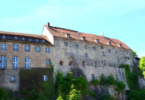 a large stone building with a red roof at Cosis Ferienwohnung in Hohnstein