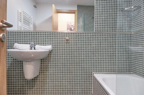 a bathroom with a sink and a bath tub at Peregrina Pension 3 in O Pedrouzo