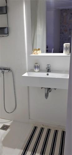 a white bathroom with a sink and a mirror at Villa Sunset Hydra in Hydra
