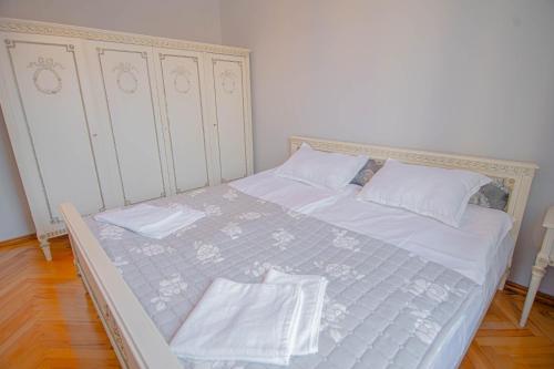 a white bed with white sheets and white pillows at Guest House "Old House" in Tʼelavi