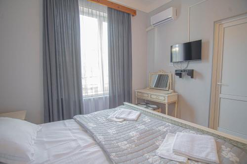Habitación de hotel con cama y TV en Guest House "Old House" en Tʼelavi