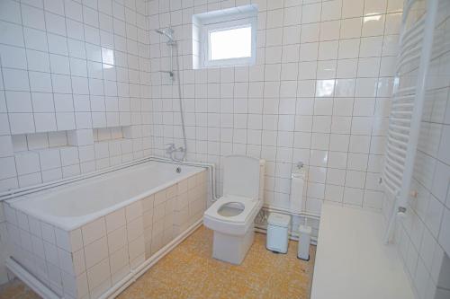 a bathroom with a tub and a toilet and a sink at Guest House "Old House" in Tʼelavi