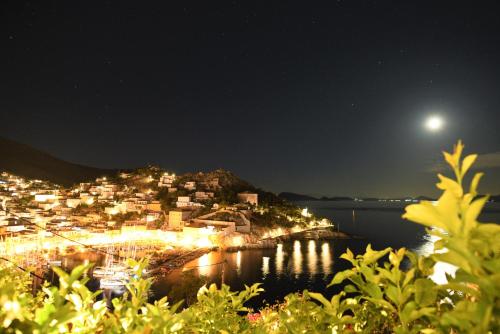 a view of a town at night with the moon at Villa Sunset Hydra in Hydra