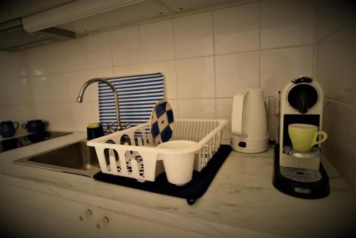 a kitchen counter with a dish drying rack next to a sink at Villa Sunset Hydra in Hydra