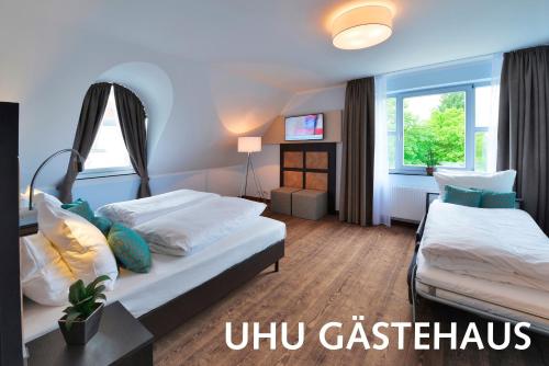 a hotel room with two beds and a window at Hotel Uhu Garni - Superior in Cologne