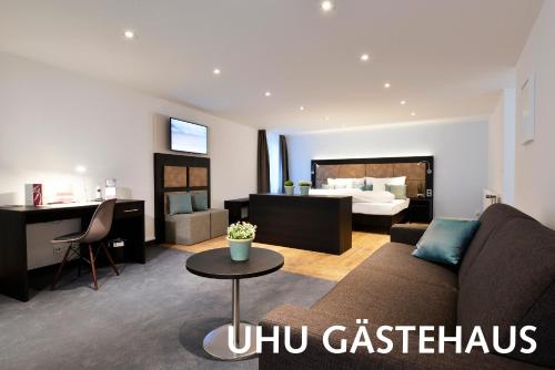 a living room with a couch and a bedroom at Hotel Uhu Garni - Superior in Cologne