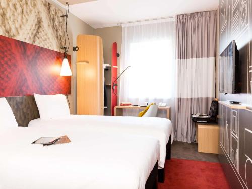 a hotel room with a white bed and white walls at ibis Vilnius Centre in Vilnius