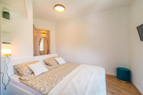 a white bedroom with a bed with white sheets and pillows at SUNSET VALA new beachfront apartment Pjescana Uvala - Medulin - Pula in Pješčana Uvala 