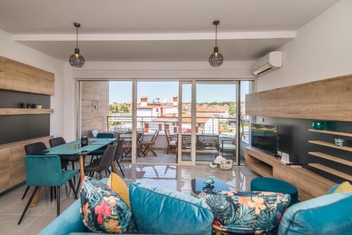 a living room with a blue couch and a table at SUNSET VALA new beachfront apartment Pjescana Uvala - Medulin - Pula in Pješčana Uvala 