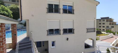 an apartment building with a balcony and a swimming pool at Zoran Apartments in Sveti Stefan