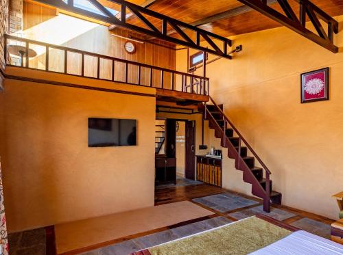 a living room with a staircase and a tv at BluSalzz Homes - The Himalayan Bungalow, Almora - Uttarakhand in Almora