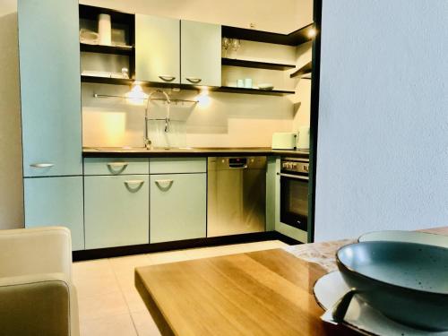 a kitchen with white cabinets and a wooden table at Ferienwohnung Mintbraun in Waldkirchen