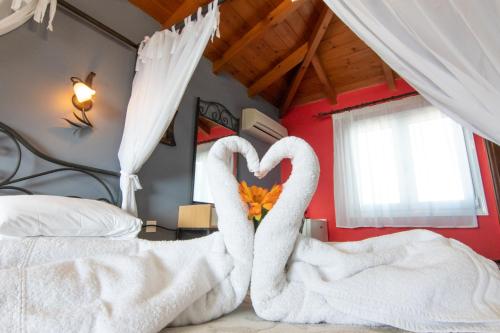 two swans making a heart on a bed at Coralli Rooms & Restaurant in Elafonisos