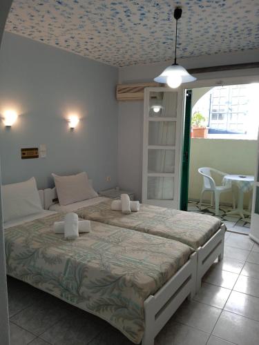 a bedroom with a large bed and a table and chairs at Hotel Anixis Resort in Naxos Chora