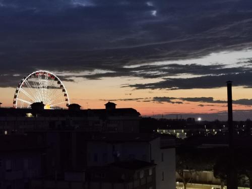 a ferris wheel in a city at sunset at Hotel Terramare in Lido di Jesolo