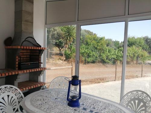 a blue vase sitting on a table in front of a window at Casa da Venda do Ferrador in Estremoz