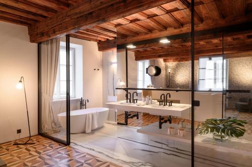 a bathroom with two sinks and a bath tub at Zlata Ladjica Boutique Hotel in Ljubljana
