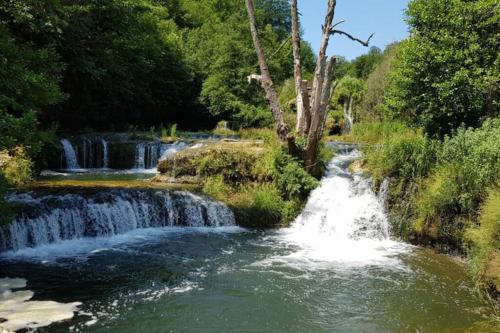 une cascade au milieu d'une rivière dans l'établissement Appartement dans le Massif du haut Jura, à Dortan