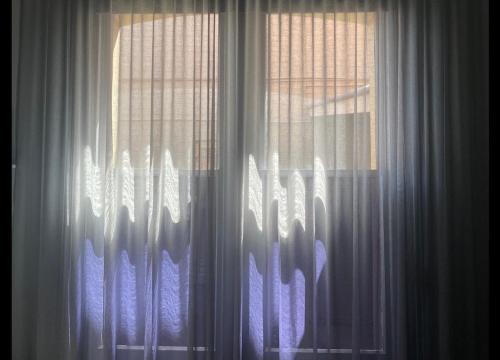 a close up of a window with white curtains at Treehouse Hideouts - Ground Level - Heygarth House Townhouse - Port of Echuca in Echuca