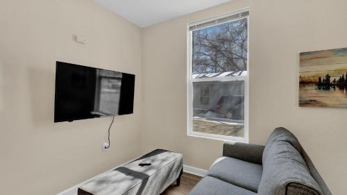 a living room with a couch and a flat screen tv at A Home Base for your Journey in Colorado Springs