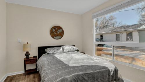 a bedroom with a bed and a large window at A Home Base for your Journey in Colorado Springs