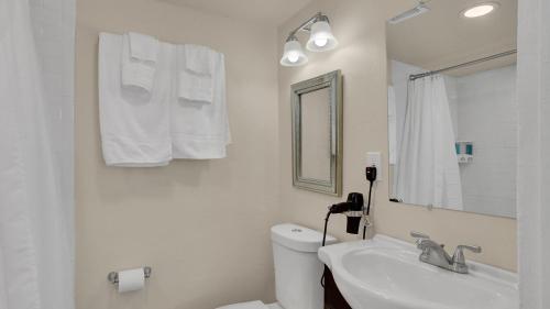 a bathroom with a sink and a toilet and a mirror at A Home Base for your Journey in Colorado Springs