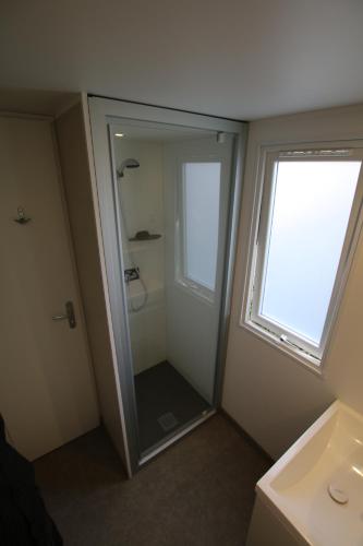 baño con ducha, lavabo y ventana en Cahita Camping Belle-Vue 2000 en Berdorf