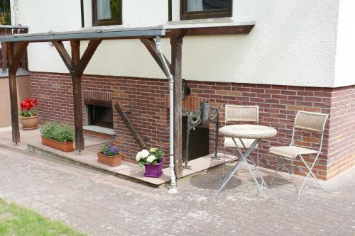 a patio with two chairs and a fireplace at Ferienwohnung Heimchen in Neuhof