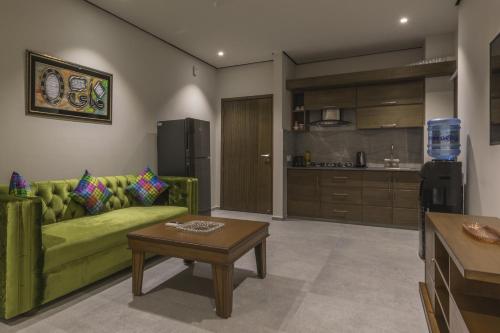 a living room with a green couch and a table at Trivelles Executive Suites Islamabad in Islamabad