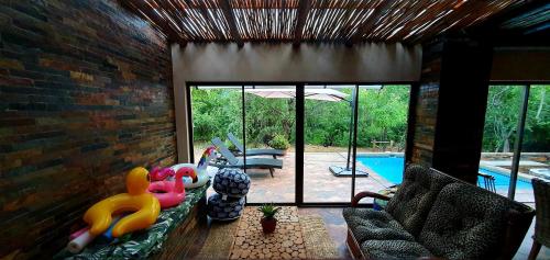 a living room with a couch and a pool at Loerie Escape - Marloth Park in Marloth Park