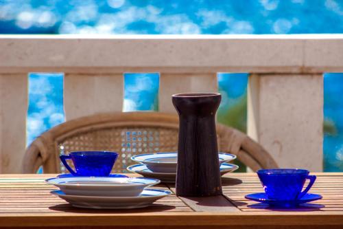 a wooden table with plates and a vase on it at Villa Magica in Pirovac