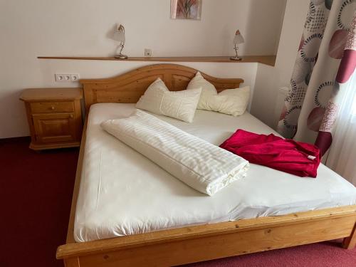 uma cama de madeira com uma bolsa vermelha em cima em Hotel Restaurant Gasthof Michal em Gundersheim