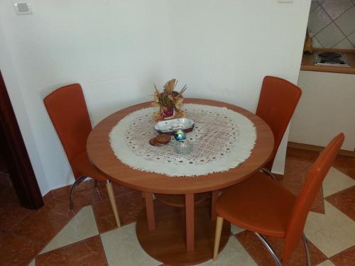 a wooden table with chairs and a bowl on it at Apartments Stevo Nikočević in Bar