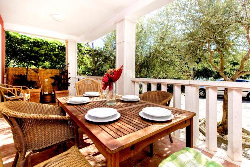 a wooden table and chairs on a porch with a table at Villa Magica in Pirovac