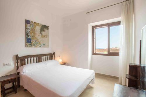 1 dormitorio con cama blanca y ventana en Creixell Sea Views, en Creixell