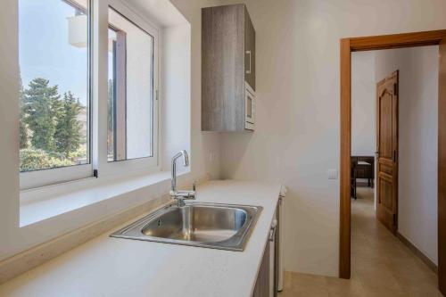 cocina con fregadero y ventana en Creixell Sea Views, en Creixell